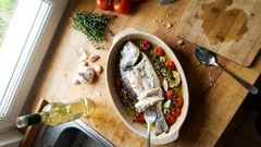 Dorade mit Tomaten im Römertopf – so wird Fisch im Ofen richtig saftig